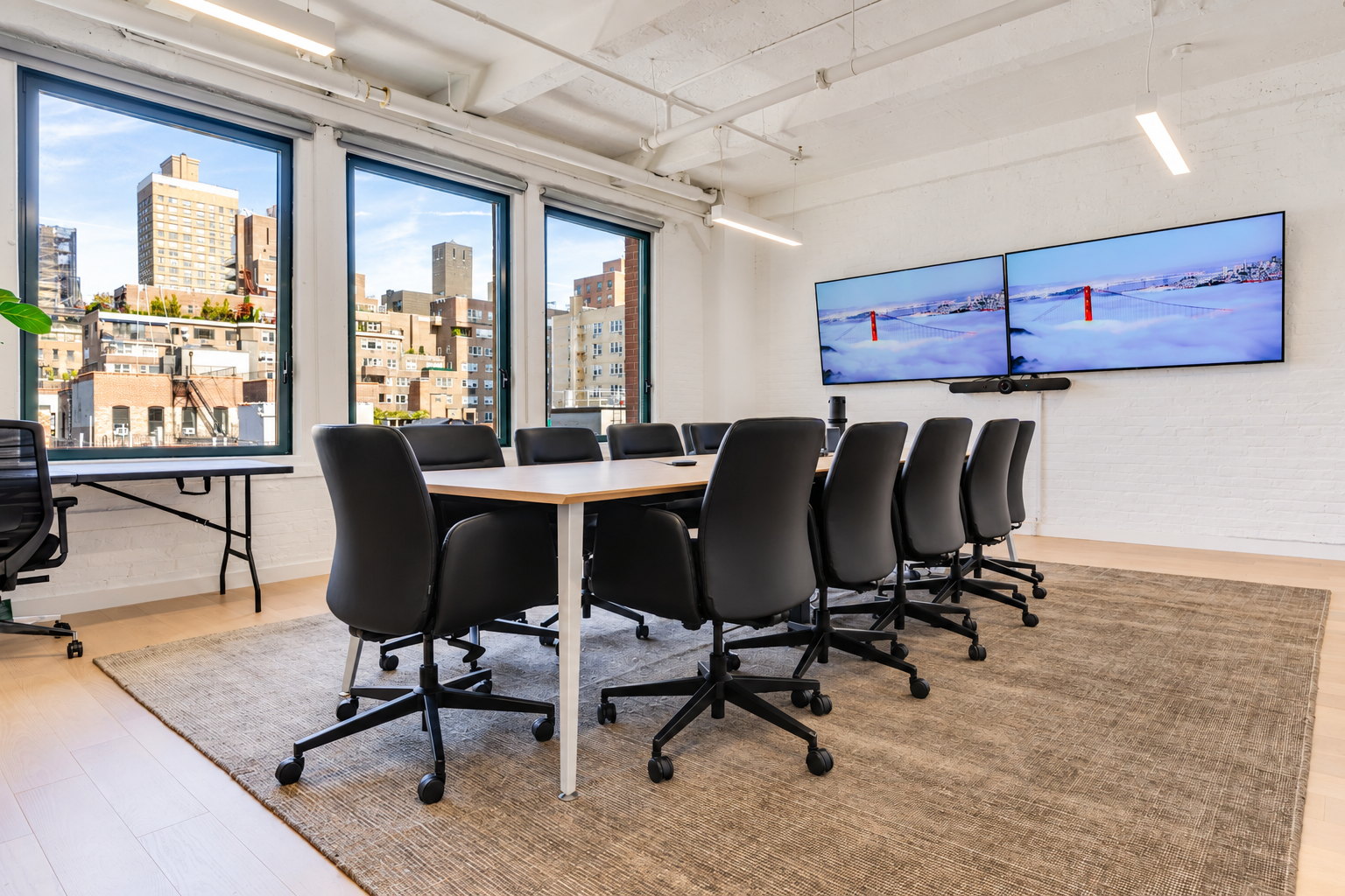 Seventh floor boardroom with a long table, twin screens and corner windows