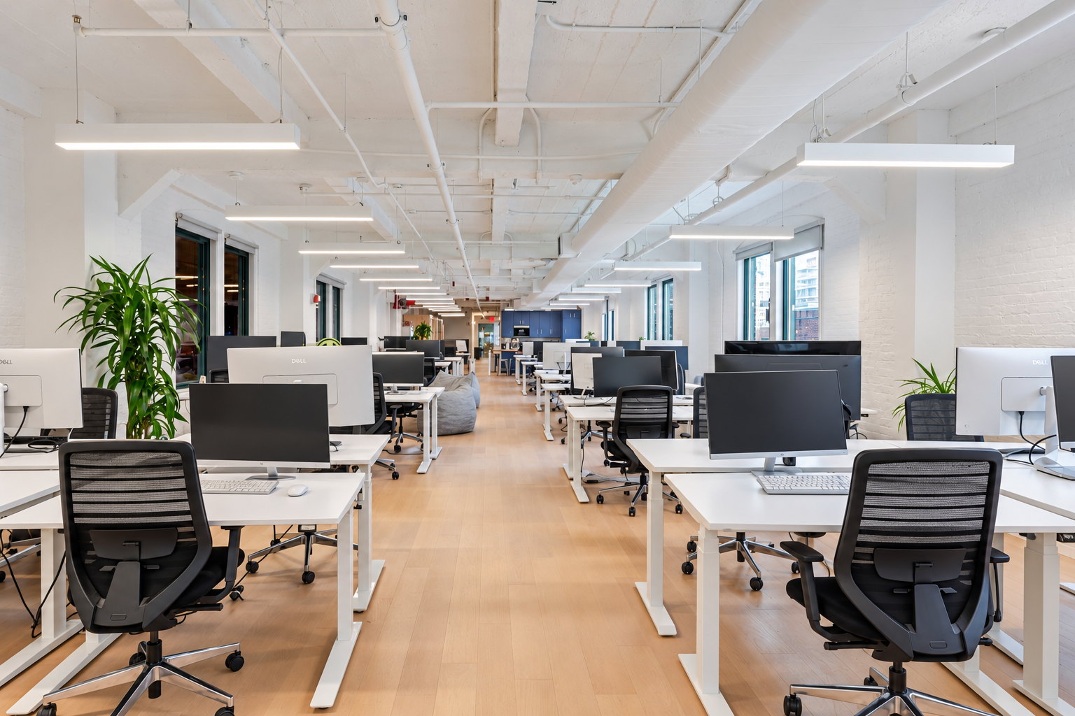 Seventh floor workstation rows under linear pendant lights with windows at both ends